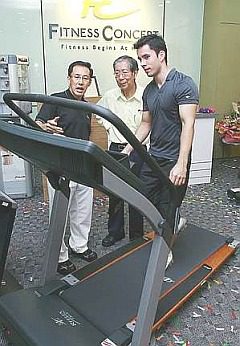 m_29treadmill Fit for all: Au Yong (left) explaining characteristics of a Fitness Concept treadmill to Olympic Council of Malaysia secretary Datuk Sieh Kok Chi as Fitness Concept ambassador Kevin Zahri demonstrates on the treadmill.